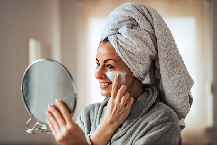 The Emotional Impact of Cosmetic Enhancement 1 beautiful smiling woman holding mirror applying face cream home 109710 1584